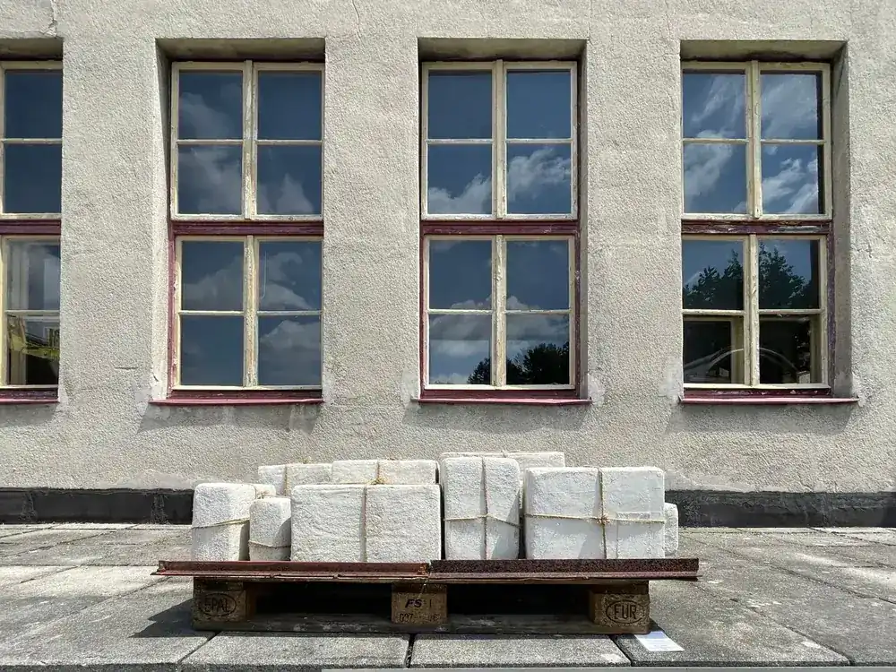 Palette de blocs de construction livrée devant la façade d'un bâtiment
