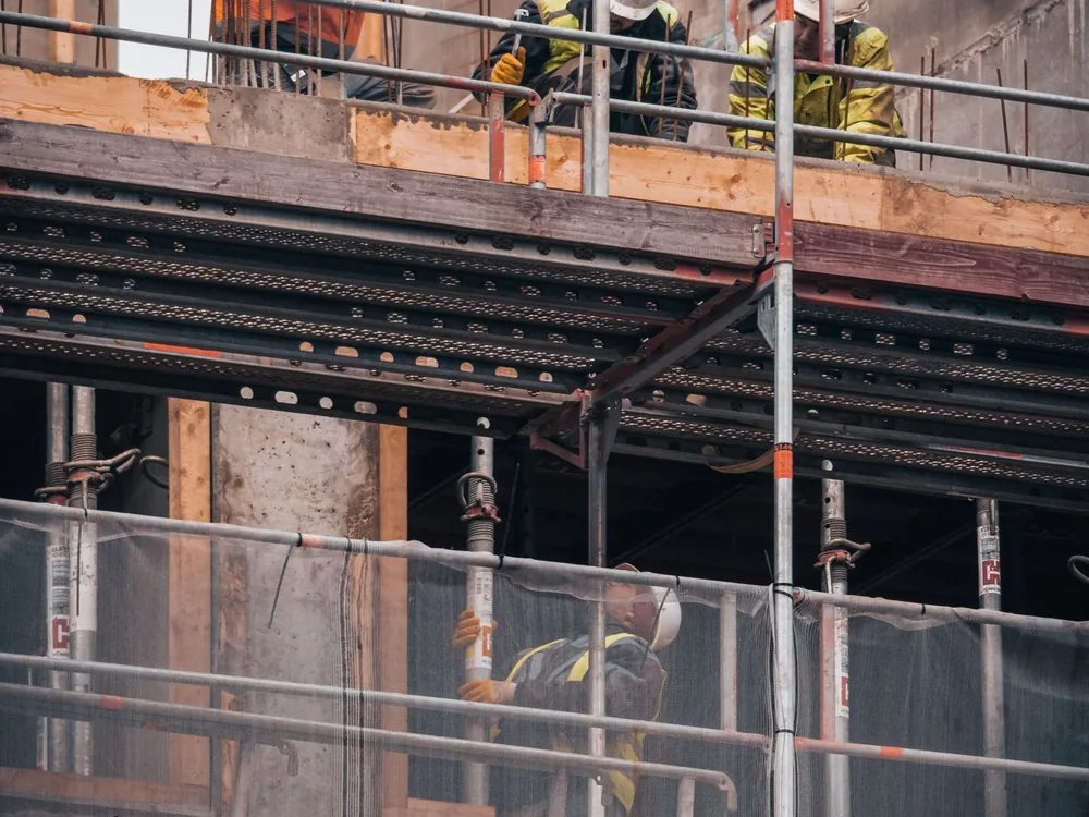Chantier de maçonnerie en cours avec échafaudage et ouvriers