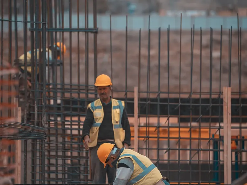 Maçon en gilet de sécurité travaillant sur un mur de briques